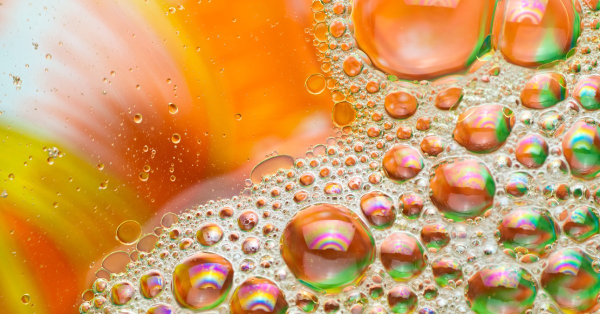 Oil droplets and surfactant in water, and bubbles of various sizes that appear to be orange and green in color.