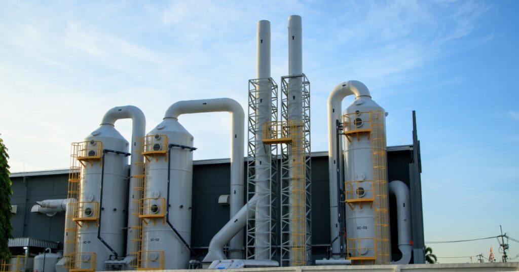 Large industrial processing facility with tall chemical towers, pipes, and filtration units at a manufacturing plant.